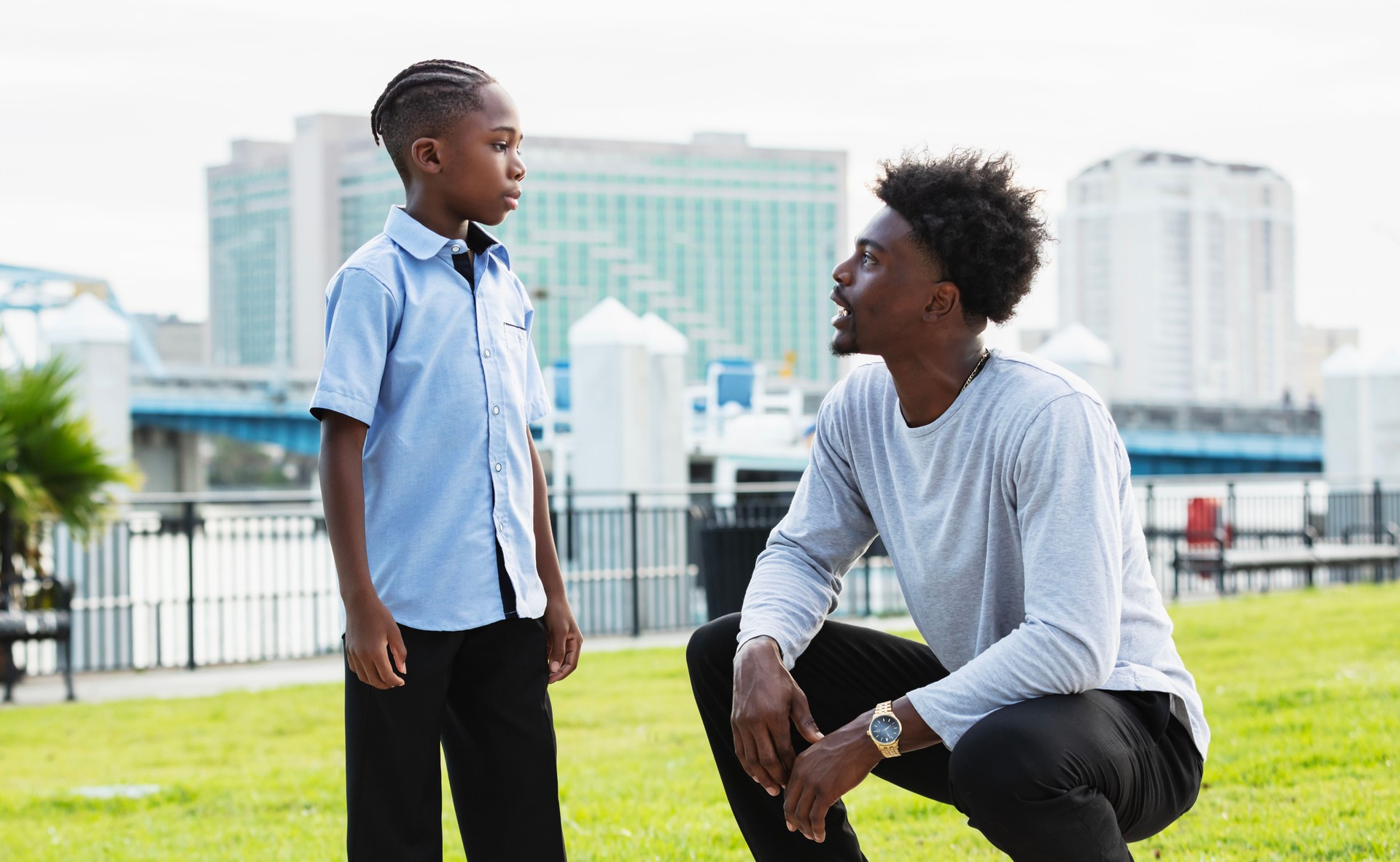 Young man talks with nephew, squatting down to eye level